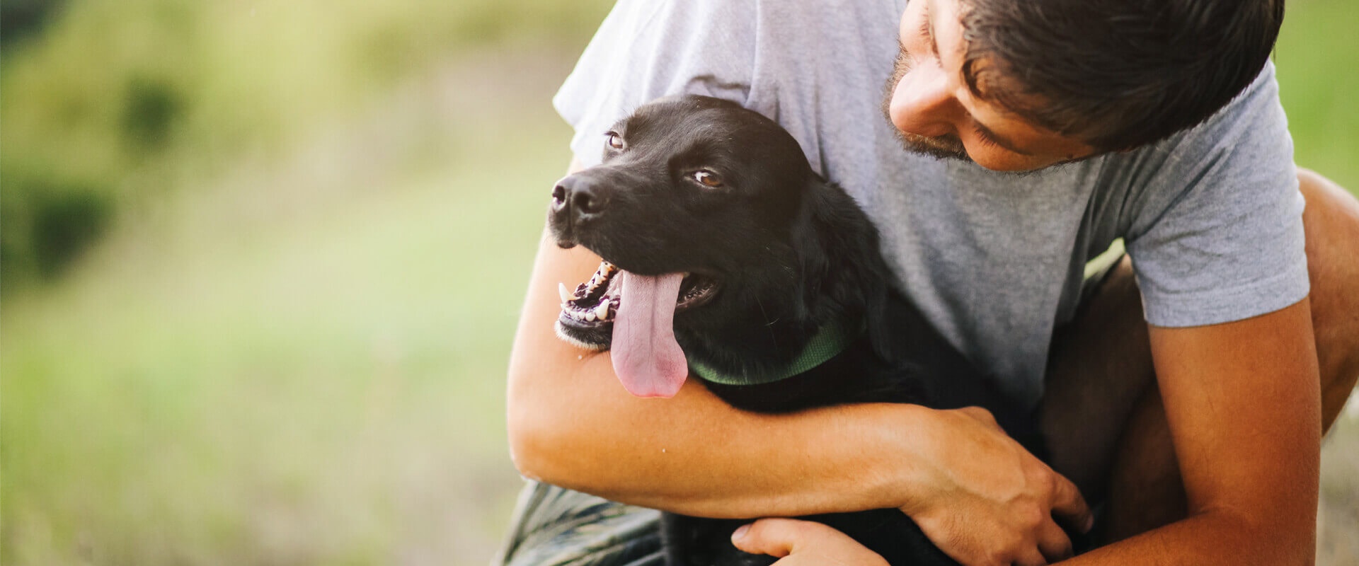Mężczyzna z czarnym psem w ramionach